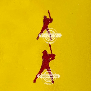 May include: Two red baseball player silhouettes are swinging bats. The silhouettes are embroidered on a yellow background. The text "Embroidery on Balls" is embroidered in red below each silhouette.