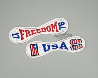 May include: Two white embroidered patches with red and blue text. One patch reads "FREEDOM 76" and the other reads "USA" with a flag design and a pair of red, white, and blue flip-flops. The patches have a white border.