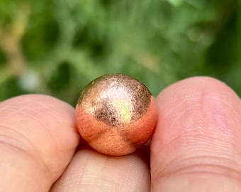 May include: A smooth, round copper sphere with a slightly reddish hue.