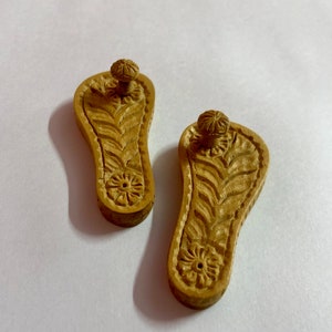 Pu&ograve; includere: Due porta incenso in legno a forma di piedi con intricate sculture. I porta incenso hanno un piccolo foro al centro del piede e una manopola nella parte superiore.