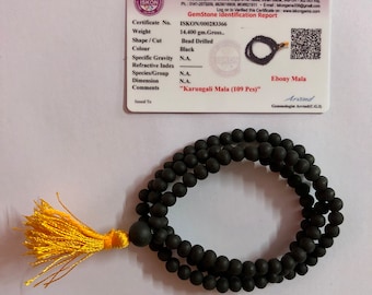 Może przedstawiać: Czarna mala z hebanu z 109 koralikami i żółtym frędzlem. Mala to sznur koralików używany do modlitwy lub medytacji. Certyfikat stwierdza, że mala waży 14,4 grama i jest wykonana z drewna hebanowego. Certyfikat stwierdza również, że mala to "Karungali Mala".
