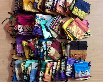 May include: A collection of colorful fabric drawstring pouches with intricate patterns and designs. The pouches are made from a variety of fabrics, including silk, cotton, and velvet. They are perfect for storing small items, such as jewelry, coins, or keys.