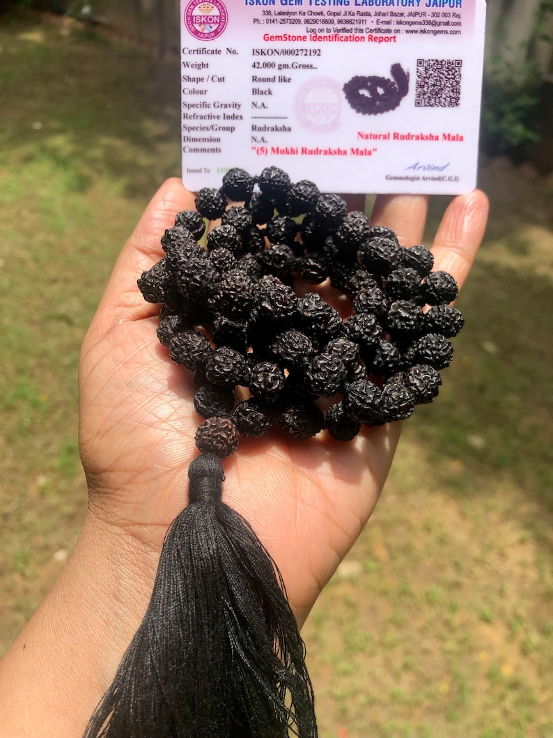 May include: A black Rudraksha Mala with a tassel. The mala is made of 5 Mukhi Rudraksha beads. The certificate states the weight is 42.000 grams.