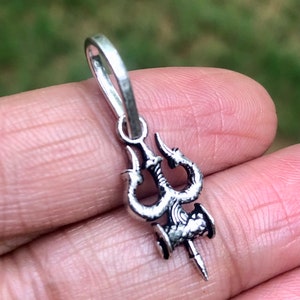 Puede incluir: Pendiente de plata con un diseño de tridente detallado. El pendiente tiene un bucle en la parte superior para sujetarlo a una cadena.