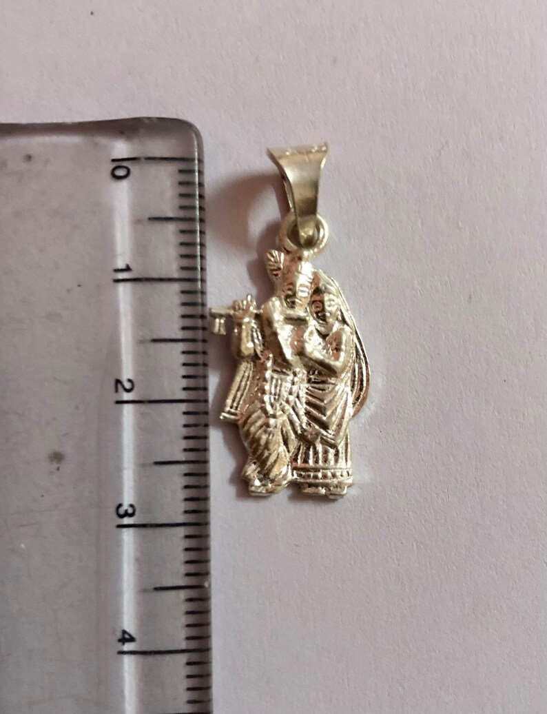 Op de afbeelding: Zilveren hanger met een gedetailleerde afbeelding van Radha Krishna, een hindoe&iuml;stisch godenpaar, dat samen staat. De hanger is ongeveer 5 cm hoog en perfect voor een ketting of een bedelarmband.