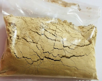May include: A plastic bag filled with a light brown powder. The powder has a cracked texture.