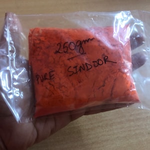 Könnte beinhalten: Eine Plastiktüte mit 250 Gramm reinem rotem Sindoor-Pulver.