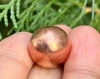 May include: A shiny copper sphere with a smooth, metallic surface.