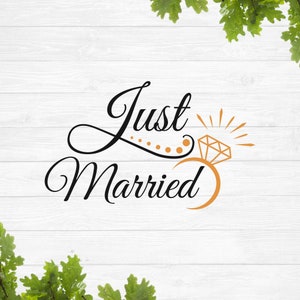 May include: A white wooden background with green leaves at the top and bottom. The text "Just Married" is written in black cursive script with a gold ring and diamond graphic to the right of the text.