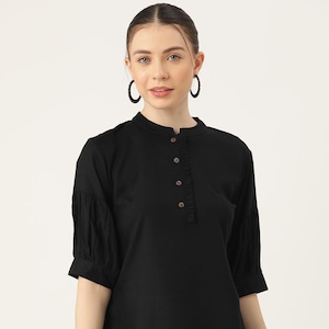 May include: A black, short-sleeved, collared shirt with a button-up front and a ruffled detail on the front. The shirt has a relaxed fit and is made of a lightweight fabric.