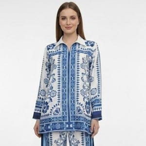 Könnte beinhalten: Zweiteiliger Pyjama-Set mit weißem und blauem Blumenmuster. Das Oberteil hat einen Kragen und einen Reißverschluss. Die Hose ist weit geschnitten mit einem blauen Streifen an der Seite. Das Set ist aus leichtem Stoff.
