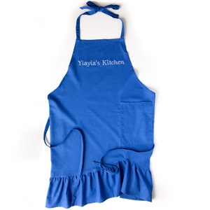 Delantal de Cocina Yiayia's Azul Letras Bordadas en Blanco con Volantes y Lazos Ajustables