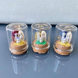Miniature Nativity scene with pearls inside a glass jar.