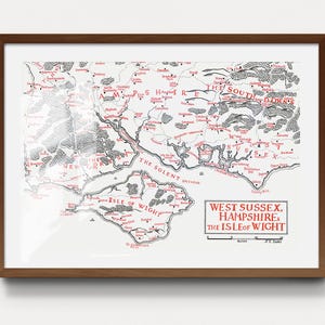 May include: A framed map of West Sussex, Hampshire, and the Isle of Wight in red and black ink on a white background. The map features detailed topography, place names, and a scale bar. The title block reads: West Sussex, Hampshire & the Isle of Wight.