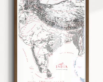 May include: A framed map of India featuring detailed black ink topography and mountain ranges on a white background. The map includes red text labels for major regions and the word INDIA printed in red near the bottom center.