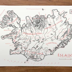 May include: A white map of Iceland featuring black topographical mountain illustrations and red text labels for regions and cities. The map includes a compass rose in the top right corner and the title &Iacute;SLAND ICELAND in the bottom right corner.