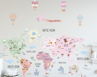 Può includere: Un adesivo da parete di una mappa del mondo rosa e verde con illustrazioni di animali e etichette di testo per ogni continente e oceano. La mappa include il titolo "Jennifer's World Map" e una piccola illustrazione di un aereo.