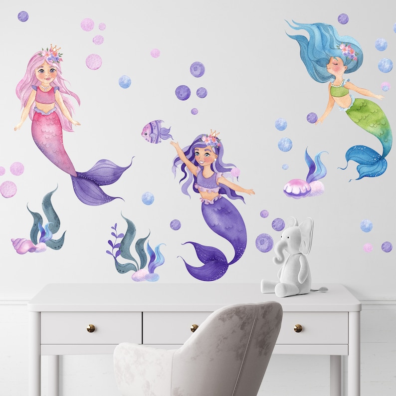 May include: Three mermaid wall decals with purple, pink, and green tails. The mermaids are surrounded by bubbles and seaweed.