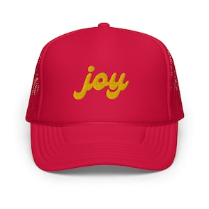 Puede incluir: Gorra de camionero roja con la palabra "joy" bordada en amarillo en la parte delantera.