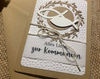Könnte beinhalten: Eine braune Karte mit einem weißen Papiereinsatz. Die Karte hat ein weißes Papierfischsymbol mit einem braunen Kranz darum. Der Text auf der Karte lautet "Alles Liebe zur Kommunion".