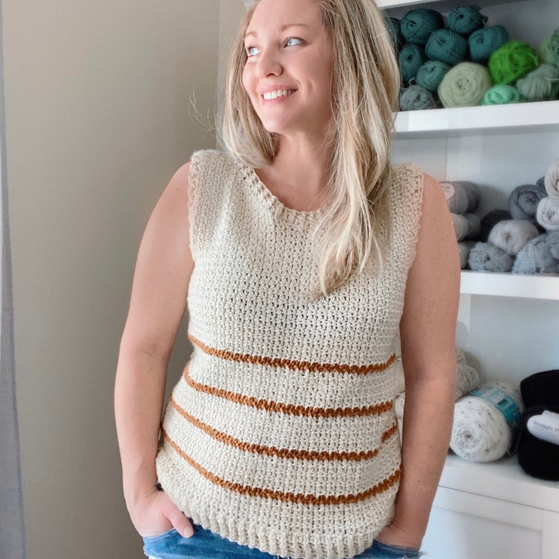 May include: A sleeveless crochet top with horizontal stripes in beige and brown. The top is made with a fine yarn and has a relaxed fit.