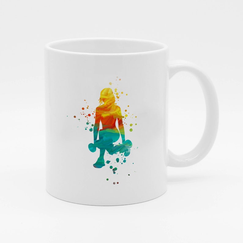 May include: White ceramic mug with a colorful silhouette of a person lifting weights. The silhouette is made up of watercolor-like splashes of color, including yellow, orange, red, blue, and green.