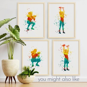 May include: Four digital art prints featuring colorful watercolor-style silhouettes of a person exercising with weights. The prints are framed in light wood frames and displayed on a white wall.