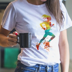 Pu&ograve; includere: Maglietta bianca con un design acquerellato colorato di una persona che corre. Il design &egrave; in tonalit&agrave; di giallo, arancione, rosso, verde e blu.