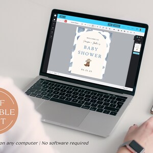 May include: A laptop displays a baby shower invitation with a cowboy theme. The invitation features a blue and white cow print design, a cowboy boot illustration, and the text "Welcome to [Names] Baby Shower 04.21.23". A smartphone sits to the right.