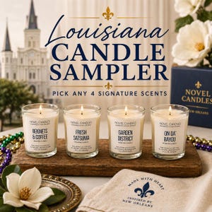 Puede incluir: Un juego de muestra de velas con cuatro velas en frascos de vidrio, cada una con una mecha encendida. Las etiquetas dicen "Beignets & Coffee", "Fresh Satsuma", "Garden District" y "On Da' Bayou". El texto "Louisiana Candle Sampler" está en la parte superior.
