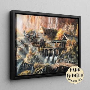 Op de afbeelding: Een ingelijste canvasprint met een gedetailleerd schilderij van een fantasienederzetting met puntdaken, stenen bogen en watervallen die langs kliffen naar beneden stromen. Een stenen brug overspant de voorgrond met kleine figuren. Tekst: HAND PAINTED ORIGINAL ART.