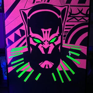 May include: Black Panther silhouette with green eyes and a pink and black geometric background. The silhouette is surrounded by a green and black patterned collar.