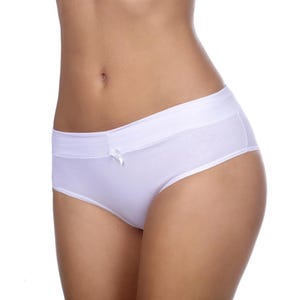 Puede incluir: Bragas blancas de talle bajo. La ropa interior tiene un pequeño lazo en la parte delantera y una cintura ancha. La tela parece ser un material suave y opaco.