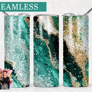 Puede incluir: Tres vasos de acero inoxidable con un patrón de mármol verde, blanco y dorado y detalles de purpurina. Los vasos son sin costuras y tienen un diseño moderno.