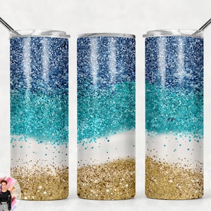 Puede incluir: Tres vasos de acero inoxidable con un diseño de purpurina. Los vasos están en capas con purpurina azul, turquesa y dorada.