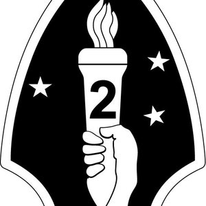 以下が含まれることがあります： 黒と白のエンブレムで、中央にトーチと数字の「2」が描かれています。トーチは手で持たれており、周りを5つの白い星で囲まれています。