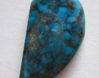 May include: A turquoise cabochon with a blue and black marbled pattern. The stone is shaped like a teardrop and has a smooth, polished surface.