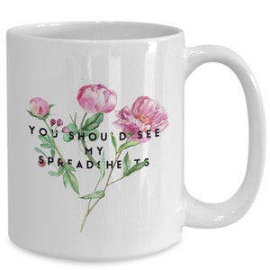 May include: White ceramic mug with a floral design and the text "You should see my spreadsheets".