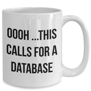 May include: White ceramic coffee mug with black text that reads "OOOH...THIS CALLS FOR A DATABASE".