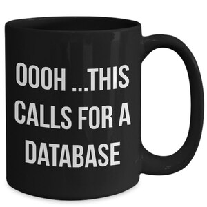 May include: Black coffee mug with white text that reads "OOOH...THIS CALLS FOR A DATABASE".