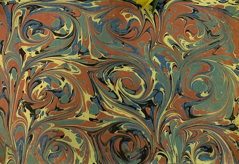 May include: Abstract marbled paper with swirling patterns in shades of red, blue, green, black, and yellow.