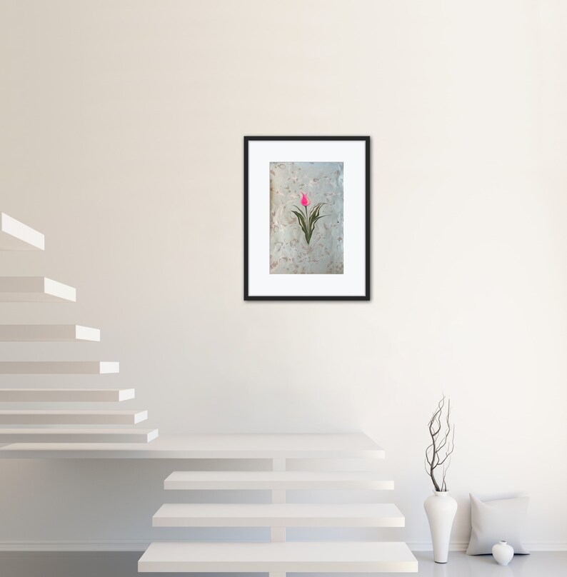May include: A framed print of a pink tulip with green leaves on a white background.
