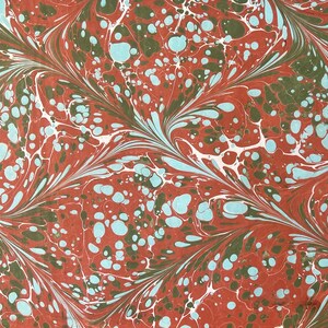 Puede incluir: Papel marmoleado abstracto con un patrón de remolino de rojo, blanco, azul y verde. El patrón se asemeja a un diseño floral con un motivo repetitivo.