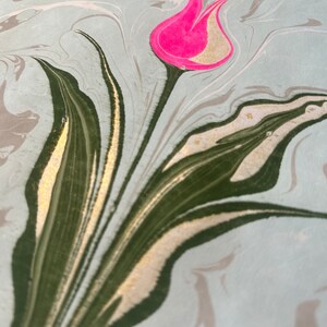 May include: A pink tulip with gold accents on a marbled background with green and gold swirls.