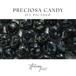May include: Close-up of a collection of dark, speckled beads. The beads are primarily black with patches of teal and green. The text "PRECIOSA CANDY JET PICASSO" is at the top, and the "strung beadery" logo is at the bottom.
