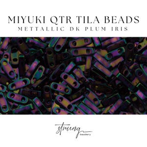 May include: Close-up of Miyuki QTR Tila beads in Metallic DK Plum Iris. The beads are rectangular with two holes, displaying a mix of iridescent colors including purple, green, and gold. The image also includes the text "MIYUKI QTR TILA BEADS" and "METALLIC DK PLUM IRIS".