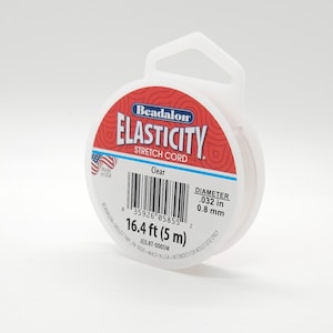 May include: Clear Beadalon Elasticity stretch cord in a white plastic spool. The spool has a red and white label with the text "Elasticity Stretch Cord". The diameter is .032 in (0.8 mm) and the length is 16.4 ft (5 m).