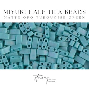 Könnte beinhalten: Ein Nahaufnahmebild von matten, undurchsichtigen Miyuki Half Tila Perlen in Türkisgrün. Die Perlen sind klein und rechteckig mit zwei Löchern in jeder Perle.