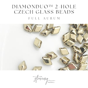 May include: Gold-colored DIAMONDUO™ 2-hole Czech glass beads. The beads are diamond-shaped with a metallic finish. The text "DIAMONDUO™ 2-HOLE CZECH GLASS BEADS FULL AURUM" is at the top of the image. The logo for "strung beadery" is at the bottom.