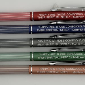May include: A collection of five pens in various colors: red, blue, gray, green, and brown. Each pen has a silver tip and clip, with the text "HAPPY ARE THOSE CONSCIOUS OF THEIR SPIRITUAL NEED." - Matthew 5:3 printed on the barrel.